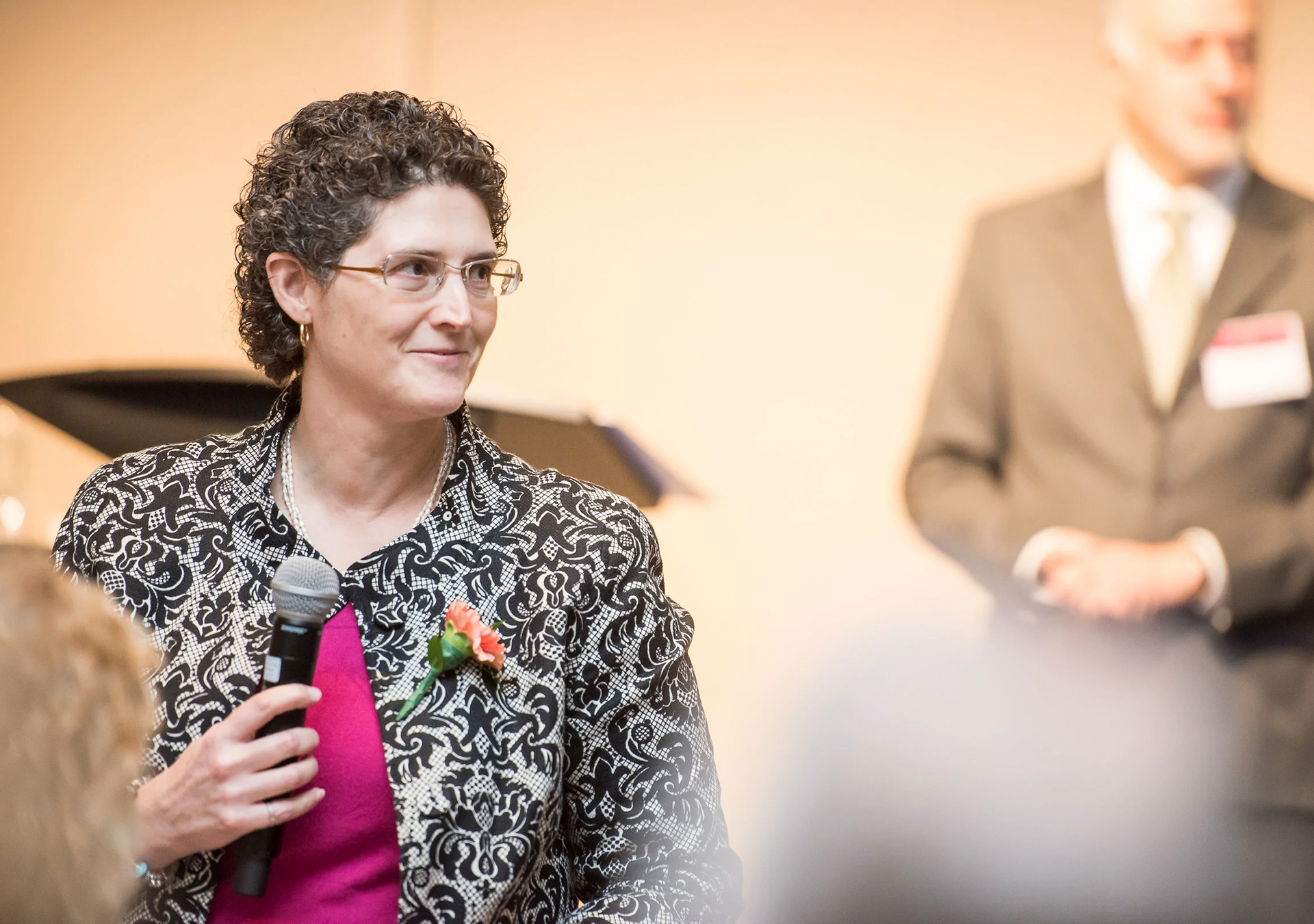 Nadine Wathen speaking with a microphone at an event