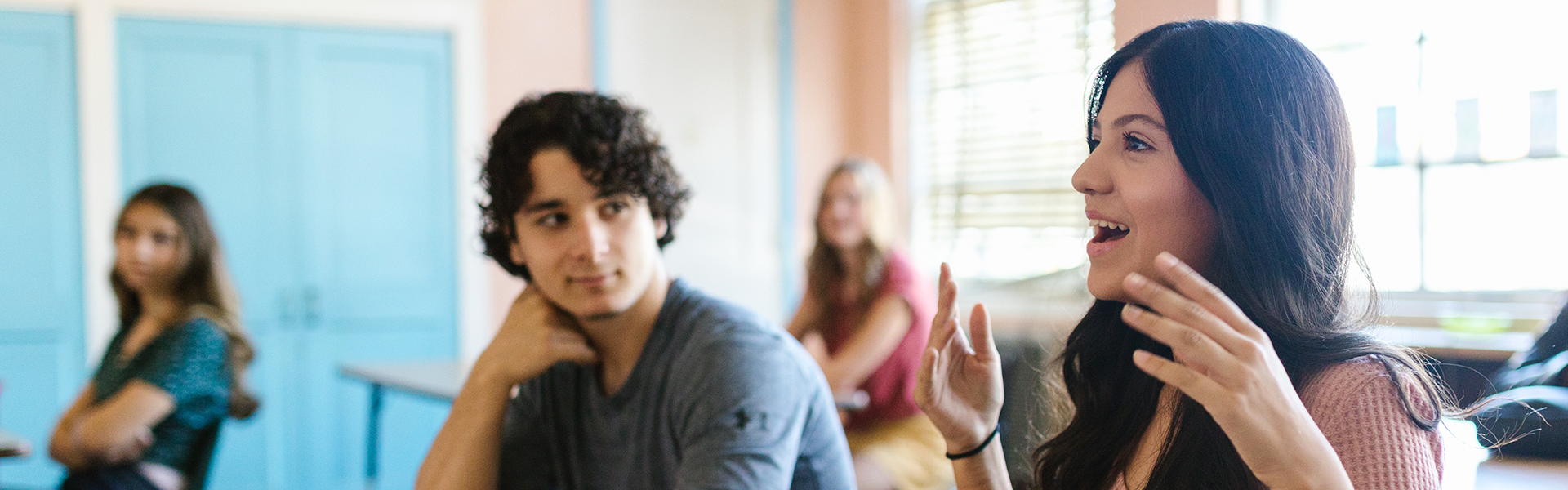 Students in a classroom talking animatedly