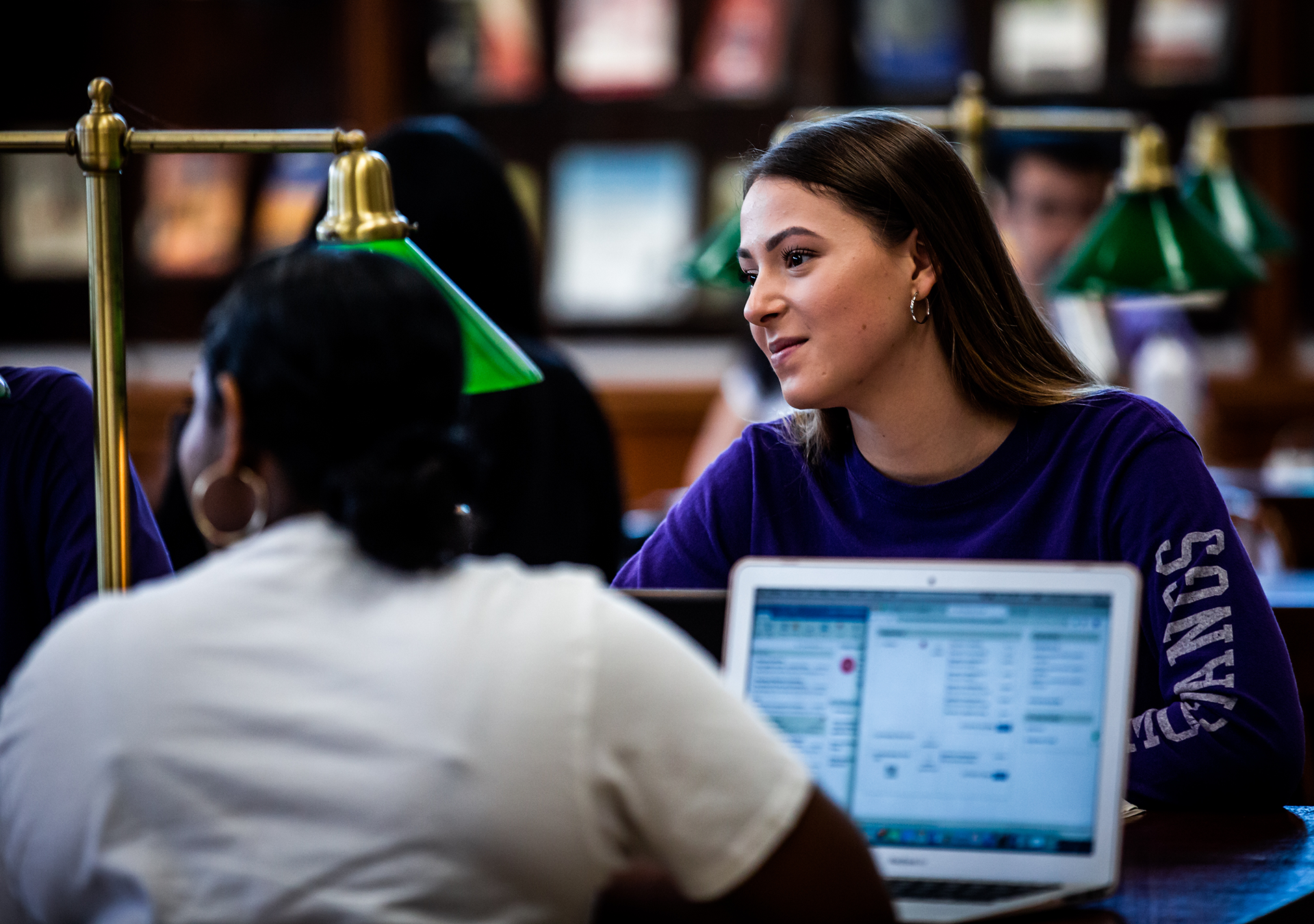 Two students collaborate in the library