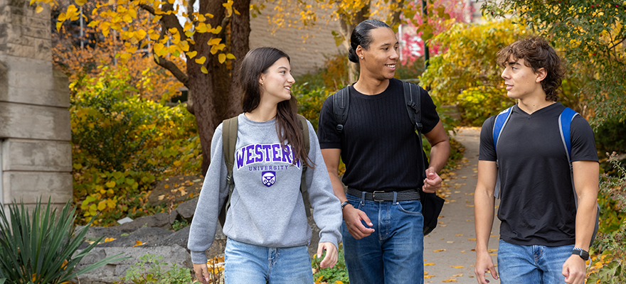 Three students walking on Western's campus in the Fall.