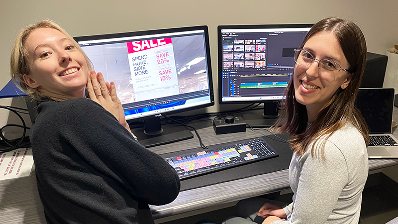 Two students working together in a video editing suite.