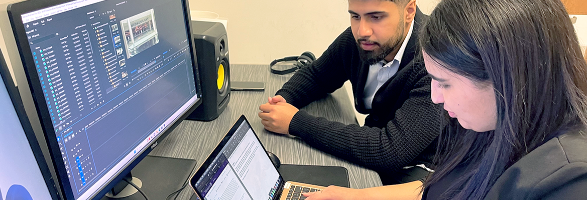 Two students working in a video editing suite