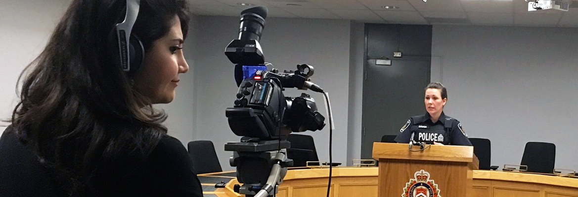 Student filming with a camera at a press conference