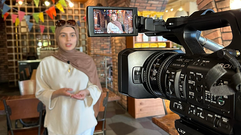 A student filming an interview subject