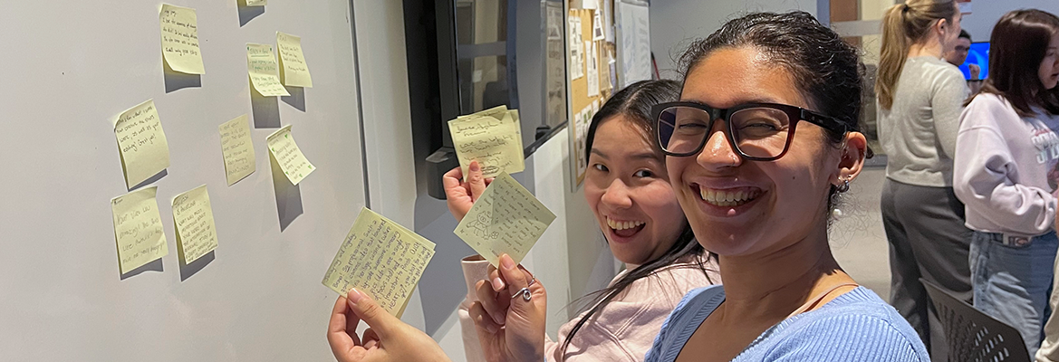 Students reading feedback on sticky notes