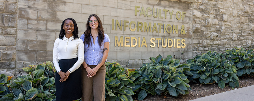 Kaylah Christie and Lexi Alarie stand outside the FIMS & Nursing Building