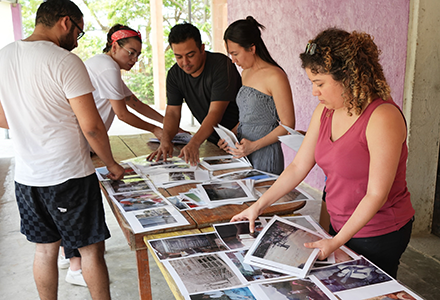 Members of the Surviving Memory team prepare photos for a workshop with the community of El Higueral, Chalatenango