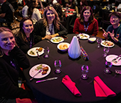 A table of alumni guests enjoy dinner at the Wave during Careerchella.