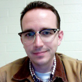 Headshot of Daniel Clarkson Fisher wearing glasses and in a beige jacket