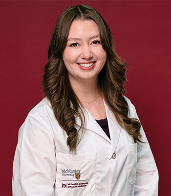 Photo of Sophie Pulumbarit in a McMaster-branded doctor's lab coat.