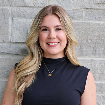 Headshot of Jillian O'Connell wearing a black, sleeveless top and a necklace