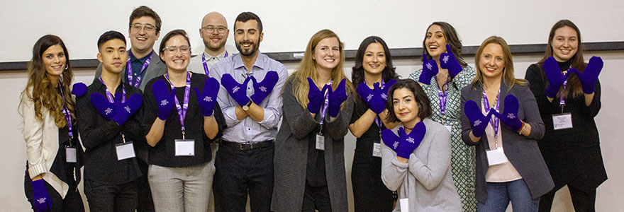 Group of FIMS alumni wearing purple mittens