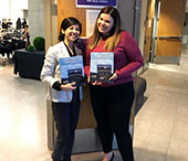 Bianca Huang and Meaghan Skinner show off the FIMS Career Conference official program.