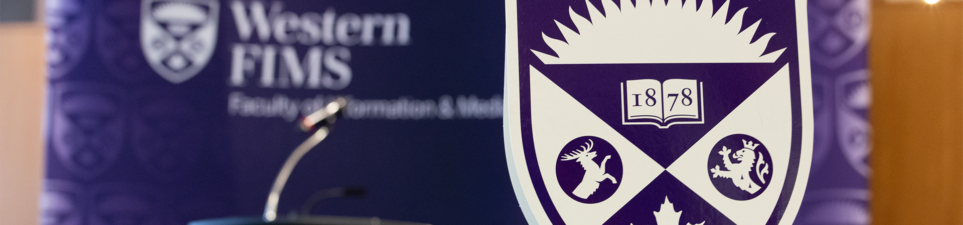 The Western University logo in the foreground with a purple banner in the background.